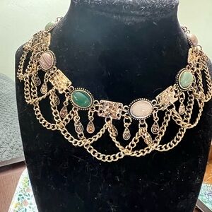 Gold tone choker necklace with fringe chains and colorful cabochons.